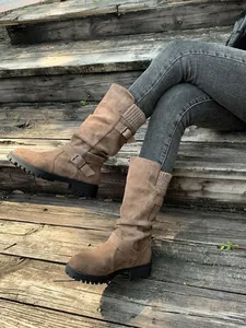 Detailed view of brown suede mid-calf slouchy boots featuring buckle straps and knitted cuffs