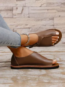 Detailansicht der braunen Damen-Flachsandalen mit offener Zehenpartie und Schnalle.