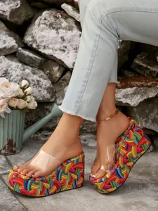 Detail of vibrant rainbow platform wedge sandals with a clear transparent PVC strap