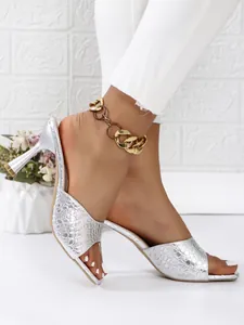 Side view of elegant silver stone-textured square toe high heel mules on model feet