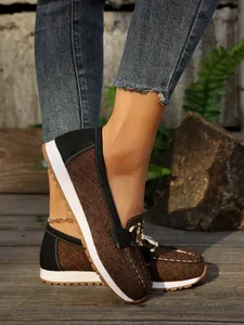 Detailed view of women's brown woven platform loafers with elegant metal chain buckle