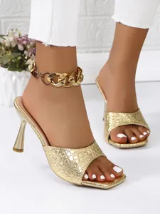 Elegant gold square toe high heel sandals with stone pattern and chain anklet decoration.