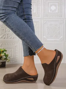Close-up view of brown platform wedge slippers for women with elegant white stitching detail