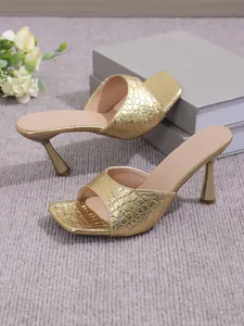 Detailed view of gold crocodile texture on elegant square-toe high-heel mules for women