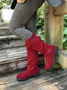 Detail showing red faux suede mid-calf boots with knitted cuffs and decorative buckles