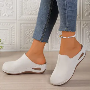 White platform wedge mules for women featuring stylish side cut-outs and slip-on design.
