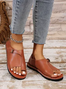 Nahaufnahme von braunen Damen-Leder-Zehentrenner-Sandalen mit Schnallen und flachen Sohlen