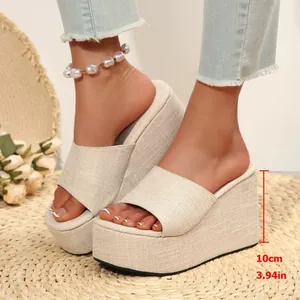 Detail shot of beige linen-textured wedge platform slides showing 10cm heel height