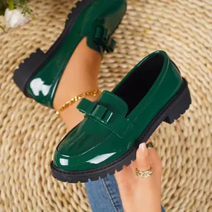 Elegant vintage dark green patent leather loafers with bow detail and thick rubber sole
