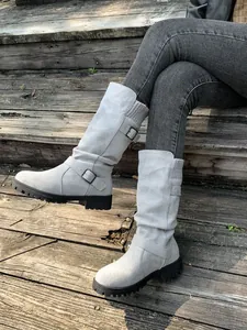 Stylish woman wearing light grey suede mid-calf boots with knit cuff and belt buckle detail