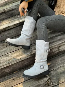 Detail view of light grey mid-calf boots with buckle strap and knitted cuff
