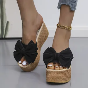 Stylish women's black wedge platform slippers with oversized bow and espadrille texture