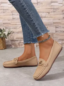 Close-up of comfortable beige loafers featuring elegant metal buckle and soft sole design