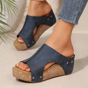 Sandales compensées bleues élégantes avec semelle en liège et détails rivetés