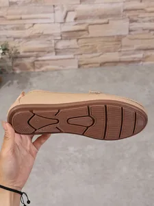 Detail view of the brown rubber anti-slip outsole for a beige loafers shoe