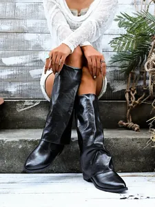 Close-up of black pointed toe gaiter boots featuring a chunky mid-heel for women