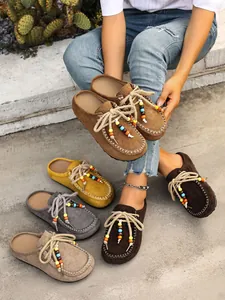Close-up detail of suede beaded platform mules showing multiple autumn color options