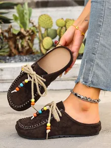 Detailed view of women's brown suede mule slippers with colorful bead accents