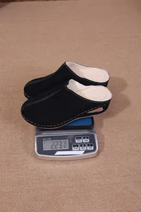 Chaussons noirs fourrés pour femmes pesés sur une balance numérique affichant 223,1 g