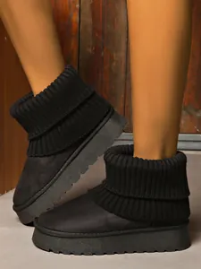 Close-up detail of black platform snow boots with knitted cuffs for extra winter warmth.