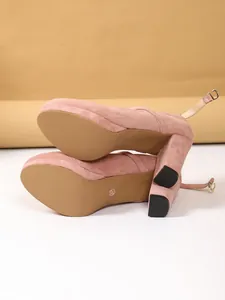 Vista dettagliata delle décolleté in camoscio rosa con tacco largo e suola in primo piano