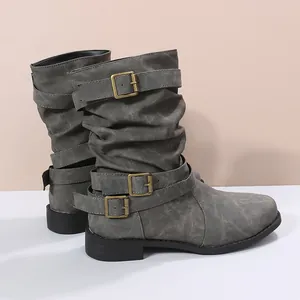 Detailansicht grauer Wadenstiefel mit Faltenwurf und dekorativen Bronzeschnallen.