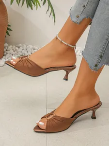 Detailed view of brown satin pointed-toe kitten heel mules with pleated pearl strap