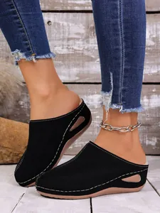 Vue latérale de mules pour femmes en suède noir avec surpiqûres et semelle épaisse