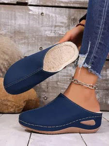 Détail des sabots à plateforme pour femmes en bleu marine doublés de polaire douce.
