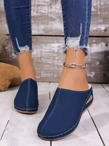 Vue détaillée des chaussons bleus avec coutures blanches et doublure chaude