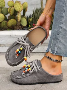 Gray suede beaded mule slippers with thick sole and boho drawstring detail.