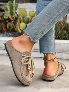 Detail of brown suede platform mules with colorful beads and rope laces