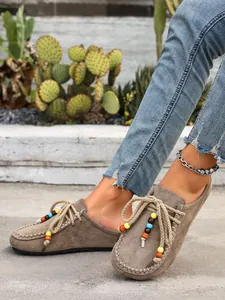 Casual women's suede platform mules with colorful beaded rope laces shown on a model