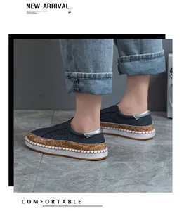 Seitenansicht von bequemen dunkelblauen Slipper-Schuhen mit Korkbesatz und weißer Sohle.
