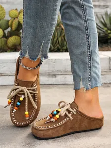 Detail showing beaded laces and suede texture on bohemian platform mules for women