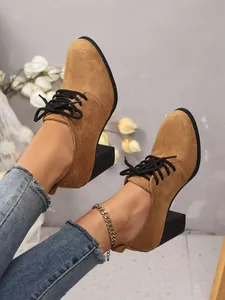 Detailansicht der braunen Wildleder-Schnürschuhe mit Absatz an einem Modell.