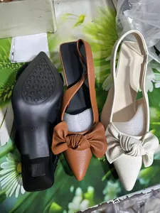 Pointed-toe slingback heels in brown white and black with large leather bow details