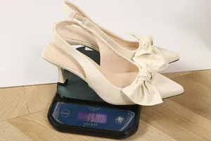 Detailed view of cream bow slingback high heels showing 358g weight on a digital scale