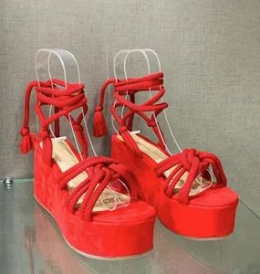 Vibrant red suede platform wedge sandals featuring intricate rope lace-up strap details