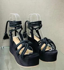 Stylish black platform wedge sandals featuring braided rope wrap-around tie-up straps and tassels