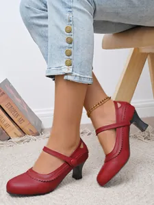 Detailansicht von roten Vintage Mary Jane High Heels mit Sektglas-Absatz auf Teppichboden