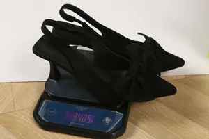 Detailed macro view showing the 340.5g weight of black bow pointed-toe slingback heels