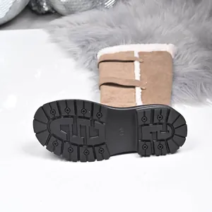 Close-up of thick lugged rubber sole and warm fleece lining on brown suede snow boots