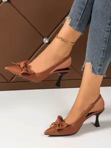 Elegant brown pointed-toe slingback pumps featuring bow detail and slim stiletto heels.