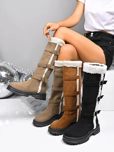 Detailed view of women's high-top snow boots with faux fur lining and buckle straps