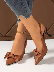 Close-up of brown pointed-toe kitten heel sandals with elegant bow detail decoration