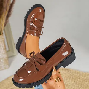 Retro brown patent leather loafers featuring tassels and bow in a classic British style