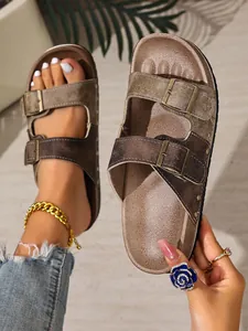 Detailed view of brown Birkenstock-style sandals featuring dual adjustable buckle straps.