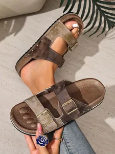 Close-up of brown distressed leather sandals with rivets and adjustable buckles