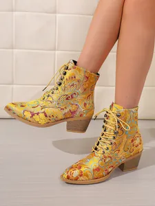 Detailansicht eleganter gelber Stiefeletten aus Satin mit Blumenstickerei und Schnürung